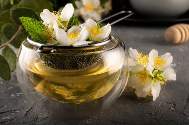 Yasemin çayı. Yasemin çiçekleri metal elek içinde demlenir. Çift alt fincan. Çiçek çayı..