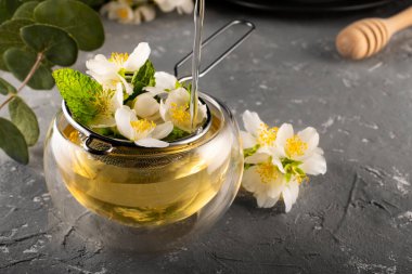 Yasemin çayı. Yasemin çiçekleri metal elek içinde demlenir. Çift alt fincan. Çiçek çayı..