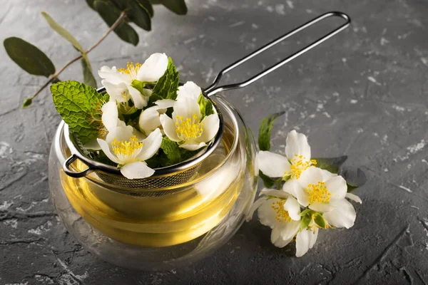 Jasmine tea. Jasmine flowers are brewed in a metal sieve. Double bottom cup. Flower tea.