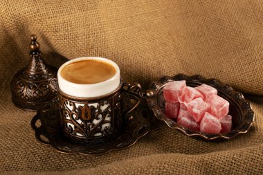 Türk kahvesi. Geleneksel oryantal demitasse desenli bakır bardak, oryantal tatlılar rahat lokum