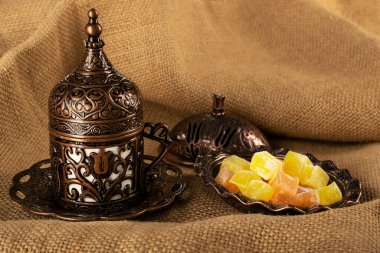 Türk kahvesi. Geleneksel oryantal demitasse desenli bakır bardak, oryantal tatlılar rahat lokum
