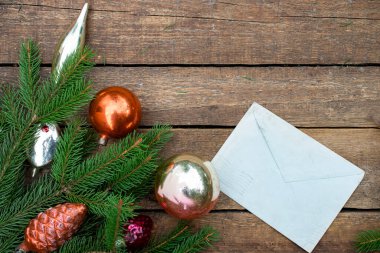 Noel ağacı süslemeleri, ladin dalları ve kartpostalların Noel kompozisyonu. Koyu ahşap doku arkaplanı.