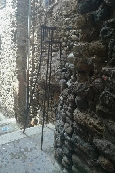 Krzesło Bardzo Wysokimi Nogami Stoi Przy Szorstkiej Kamiennej Ścianie Hiszpania — Zdjęcie stockowe