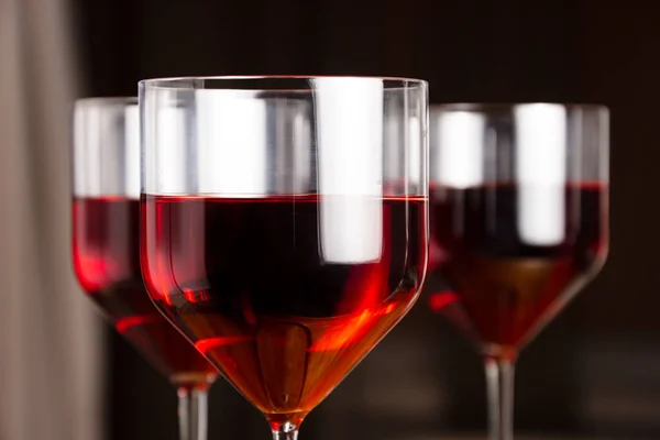 Three glasses of red wine on a dark background. Shallow depth of field. Blurred background