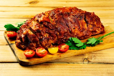 Ahşap arka planda kesim tahtasındaki klasik köfte. Arka planda kırmızı ve sarı kiraz domatesleri, maydanoz ve buğday kulakları var.