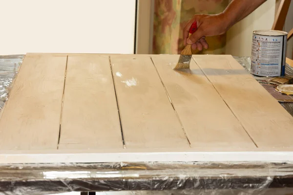 A carpenter makes a wooden background for subject shooting. Yellow color