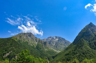 Kuzey Osetya 'nın güzel kırsal manzarası. Güneşli bir gün. Dağlardaki güzel yaz manzarası. Otlaklar ve tepeler. Kırsal alanlar