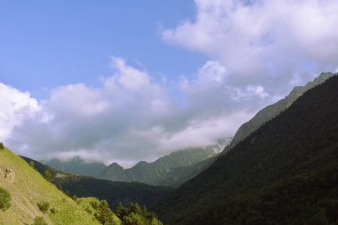 Kuzey Osetya 'nın güzel kırsal manzarası. Güneşli bir gün. Dağlardaki güzel yaz manzarası. Otlaklar ve tepeler. Kırsal alanlar