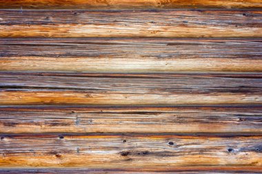 Kütük duvarın ön cephesinin bir parçası. Köy duvarının yatay ahşap arka planı. Boyanmamış ahşap bir ahır ya da ev duvarı parçası. Boşluğu kopyala