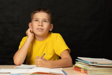 Çocuk ödevi çözme, yukarı bakma, düşünceli..