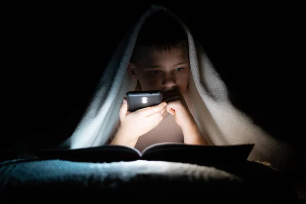 Menino Deitado Cama Lendo Livro Escuro Iluminando Com Uma Lanterna — Fotografia de Stock