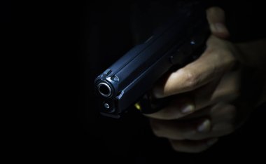 Erkek el jest deneyin birini silahla, koyu arka plan ile silahlı adam öldürmek için gösterilen kapatın