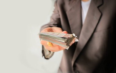 Beyaz arka plan ile pek çok para veren takım elbiseli işadamı