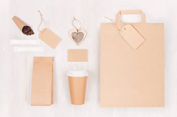 Mockup packing for coffee products and shop - brown paper cup, blank bag, packet, label, card, heart, coffee beans, sugar on white wood board.
