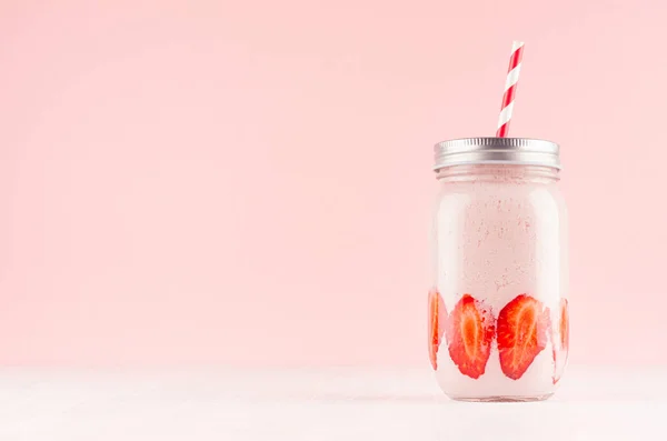 新鲜的乳品鸡尾酒草莓在罐子与多汁的浆果和红色条纹秸秆在罐子在白色木板和柔和的粉红色墙壁 复制空间 — 图库照片