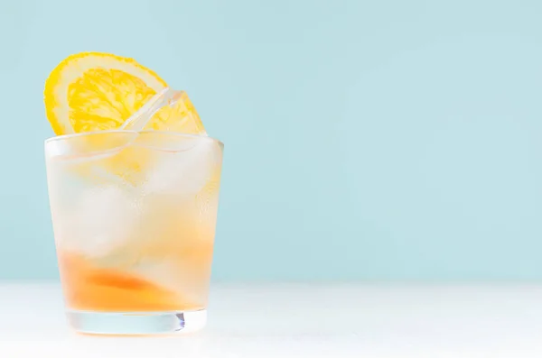 オレンジ酒 スライスオレンジ 白い木製のテーブルと青い色の壁に霧のショットグラスのアイスキューブと新鮮なショットカクテル — ストック写真