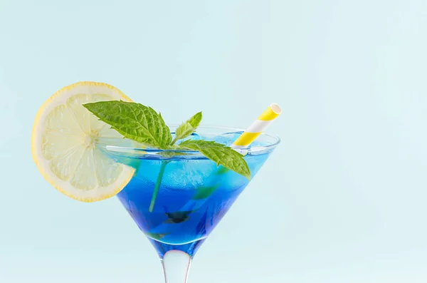 年轻的新鲜酒精蓝色夏威夷鸡尾酒 配以甘草 柠檬片 酒瓶中的黄色稻草 薄荷背景 — 图库照片