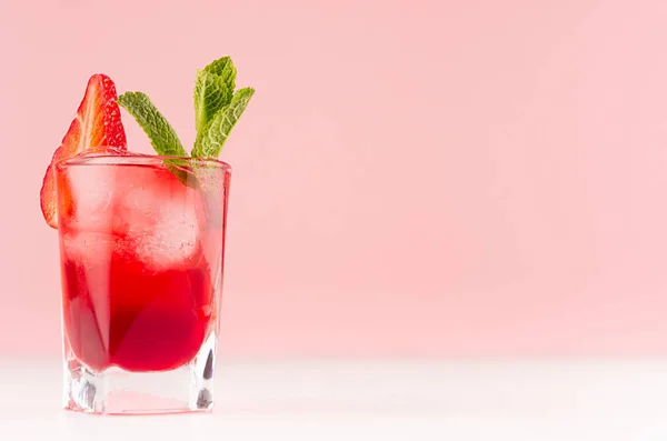 红色甜冷党饮料在优雅的射击玻璃与冰块 草莓片 绿色薄荷上柔和的粉红色颜色背景 白色木板 — 图库照片