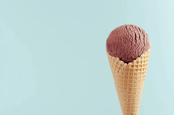 パステルグリーンの背景に鮮明なワッフルコーンでチョコレートブラウンクリーミーなアイスクリーム クローズアップ トップ — ストック写真