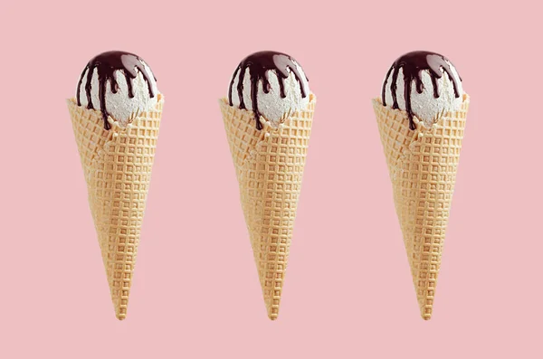 ピンクの背景にチョコレートソースとサクサクワッフルコーンの3つの白いアイスクリームのセット — ストック写真
