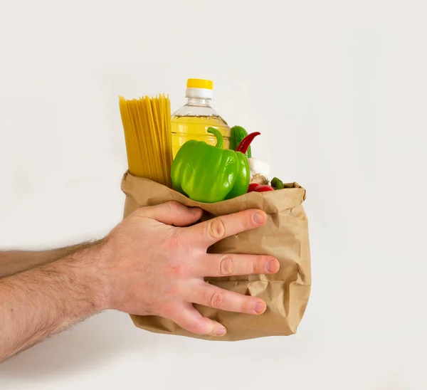 Man Passes Paper Bag Vegetable Oil Pasta Cucumbers Tomatoes Onions — Stock Photo, Image