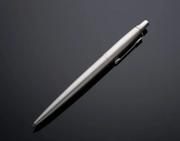 metal pen on a gray background. concept mock up for corporate busines identity presentation. Drawing and writing.