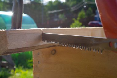 Bir el testeresi ve testere kullanarak. ahşap ev inşa kavramı.