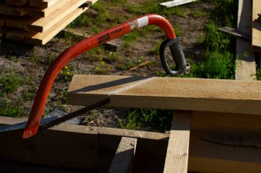 Bir el testeresi ve testere kullanarak. ahşap ev inşa kavramı.