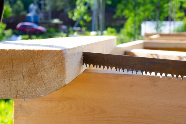 Bir el testeresi ve testere kullanarak. ahşap ev inşa kavramı.