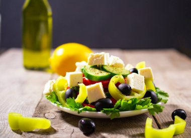 Taze salatalık, domates, tatlı yeşil biber, marul, kırmızı soğan, beyaz peynir ve zeytinyağlı zeytin. Sağlıklı yiyecekler. Boşluğu kopyala.