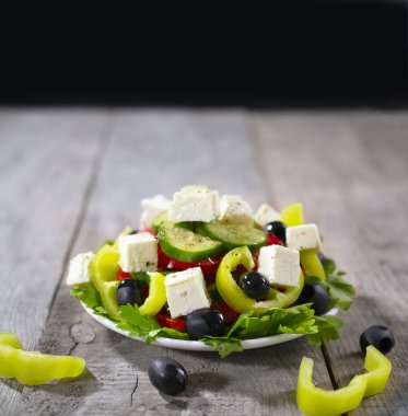 Taze salatalık, domates, tatlı yeşil biber, marul, kırmızı soğan, beyaz peynir ve zeytinyağlı zeytin. Sağlıklı yiyecekler. Boşluğu kopyala.