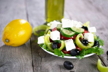 Taze salatalık, domates, tatlı yeşil biber, limon, kırmızı soğan, zeytinyağlı beyaz peynir ve zeytin. Sağlıklı yiyecekler. kopyalama alanı. düz yat.