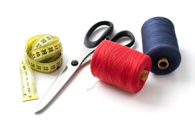 Terzi makası, inç, santimetre bant, beyaz arka planda dikiş ipliği. Boşluğu kopyala.