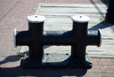 Limandaki iskelede siyah Bollard. Boşluğu kopyala.