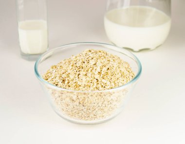 Bir sürahi sütün yanında cam tabakta yulaf ezmesi. Yüksek ışıkta kahvaltı kavramı.