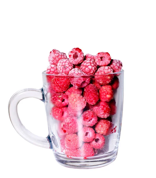 Masada yansıması olan beyaz bir masada cam bir şişede taze donmuş ahududular. Bayram için hasat ahududu turtası konsepti.