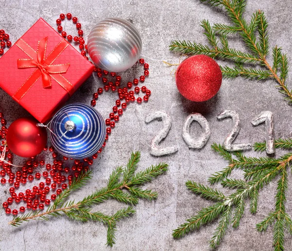 parmaklar yirmi bir, Noel süslemeleri olan yeşil bir dal ve içinde hediye olan bir kutu, çimento arka planda Noel kompozisyonu. Düz konum, üst görünüm, kopyalama alanı.