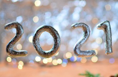 Bulanık gümüş ışıklara karşı 2021 numara. Yeni yıl konsepti. Boşluğu kopyala.