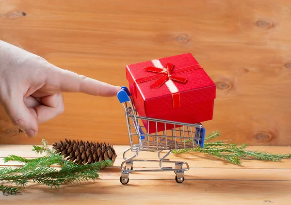 Miniatűr Bevásárlókocsi Kerekeken Tele Ajándékdobozokkal Háttér Ágak Egy Karácsonyfa Kúp — Stock Fotó