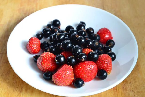 Fresas Grosellas Negras Plato Blanco Mesa Madera Cosecha Alimentos Frescos — Foto de Stock