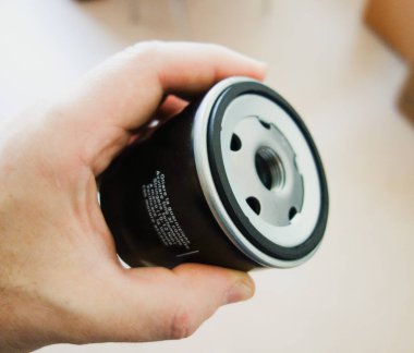 Bir araba için motor yağı değiştiren bir adam yeni bir yağ filtresi tutar. konsept araba bakım ve onarım. Boşluğu kopyala.