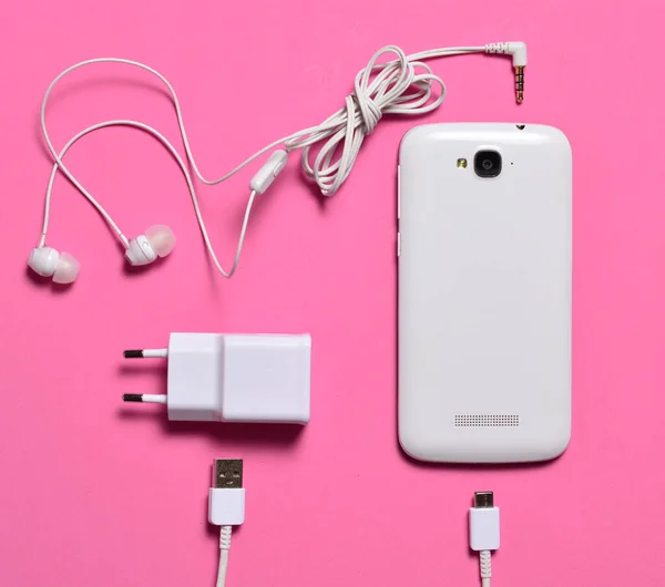 Růžovém Pozadí Bílý Smartphone Sluchátky Nabíjení Kabel Kopírovat Prostor Pohled — Stock fotografie