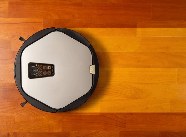 Robot elektrikli süpürge parke zeminini temizler ve yıkar, üst manzara, yazı için yer. Evdeki temizlik konsepti. kopyalama alanı. düz yat.
