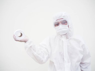 Elinde tuvalet kağıdı tutan Asyalı erkek doktor ya da PPE süit üniformalı bilim adamı. Koronavirüs karantinasında tuvalet kağıdı eksikliği. COVID-19 kavramı izole edilmiş beyaz arkaplan