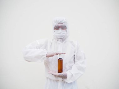 PPE üniformalı doktor ya da bilim adamının portresi. Elinde plastik şişeyle cilt bakımı ürünü taşıyor. COVID-19 kavramı izole edilmiş beyaz arkaplan