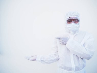 PPE üniformalı Asyalı erkek doktor ya da bilim adamı parmaklarını fotokopi uzayını işaret ederken ileri ve ileri bakıyor. Coronavirus veya COVID-19 kavramı izole edilmiş beyaz arkaplan