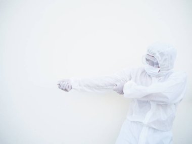 PPE süit üniformalı Asyalı doktor ya da bilim adamı beyaz arka planda güçlü bir görünmez halat çekmeye çalışıyor. Coronavirus veya COVID-19 kavramı