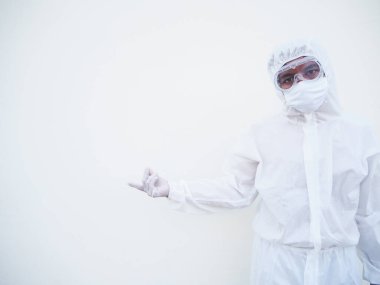 PPE üniformalı Asyalı erkek doktor ya da bilim adamı parmaklarını fotokopi uzayını işaret ederken ileri ve ileri bakıyor. Coronavirus veya COVID-19 kavramı izole edilmiş beyaz arkaplan