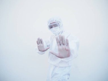 PPE süit üniformalı Asyalı erkek doktor ya da bilim adamı geleceğe bakarken dur işareti gösteriyor. Coronavirus veya COVID-19 kavramı izole edilmiş beyaz arkaplan