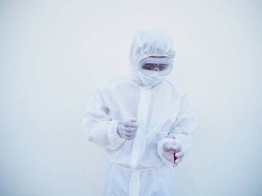 PPE süit üniformalı Asyalı doktor ya da bilim adamı. Kişisel koruyucu giysi kan testi tüpüne kan damlatıyor. Coronavirus veya COVID-19 kavramı izole edilmiş beyaz arkaplan